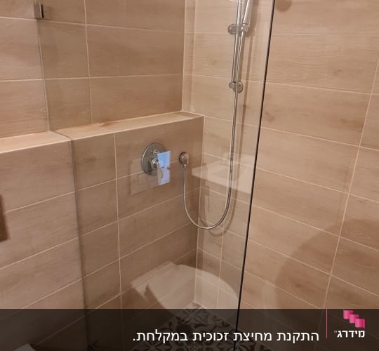 מחיצת זכוכית במקלחת עם ראש מקלחת